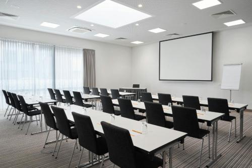 a conference room with tables and chairs and a whiteboard at Four Points Flex by Sheraton Essen in Essen