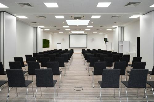 a conference room with black chairs and a whiteboard at Four Points Flex by Sheraton Essen in Essen