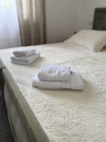 two towels sitting on top of a white bed at Luna Guest House in Durrës