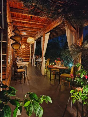 a restaurant with tables and chairs and plants at Czarna Owca in Istebna