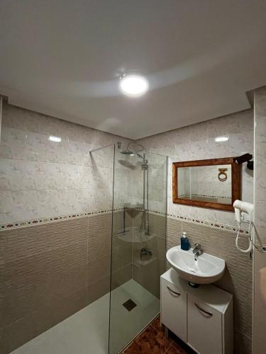 a bathroom with a glass shower and a sink at Apartamentos Ruidera in Ruidera
