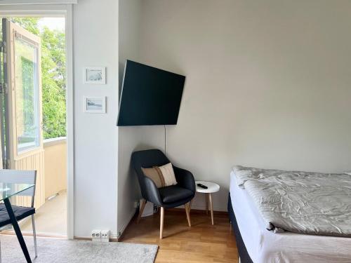 a bedroom with a bed and a chair and a window at Lauttasaari Studio in Helsinki