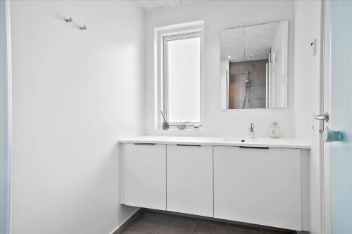 Un baño blanco con lavabo y espejo. en 914-Hvide-Sande-Langsand-196-1-sal, en Hvide Sande