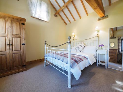 a bedroom with a white bed and a wooden ceiling at 1 Bed in Ashford in the Water PK574 in Great Longstone