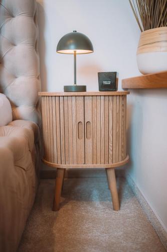 a wooden table with a lamp on top of it at Sedmé Nebe Apartmán in Děčín