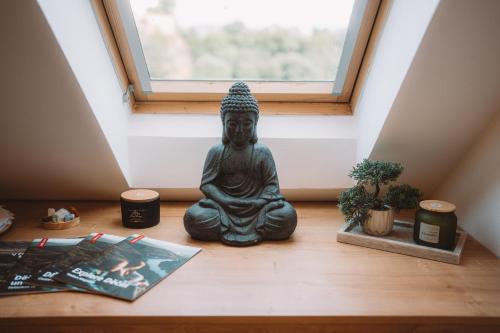 a statue sitting on the floor in front of a window at Sedmé Nebe Apartmán in Děčín