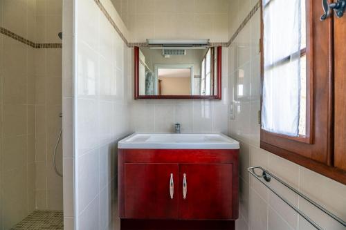 La salle de bains est pourvue d'un lavabo rouge et d'un miroir. dans l'établissement La Tour du Fauconnier, à Sergeac