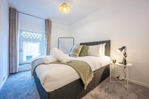 a bedroom with a large bed and a window at Silver Street by Tŷ SA in Troed-y-rhiw