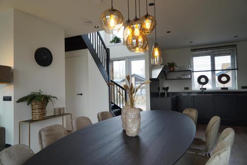 a dining room with a table with a vase on it at Pavilion Villa Waterzicht | 10 Personen in Kerkdriel