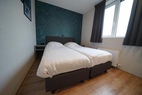 a bedroom with a large bed with white sheets at Pavilion Villa Waterzicht | 10 Personen in Kerkdriel