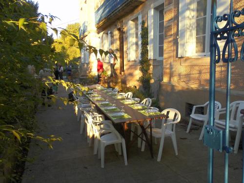 une longue table et des chaises assises à l'extérieur d'un bâtiment dans l'établissement Domaine du Vern, à Saint-Affrique