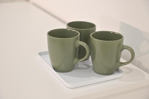 three green cups sitting on a white shelf at Domus Cassino Centro in Cassino