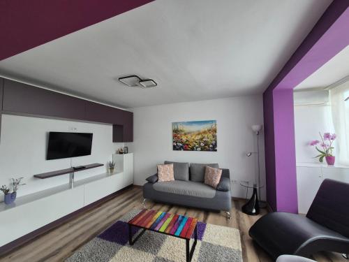a living room with purple and white walls at Apartament ASR in Piatra Neamţ