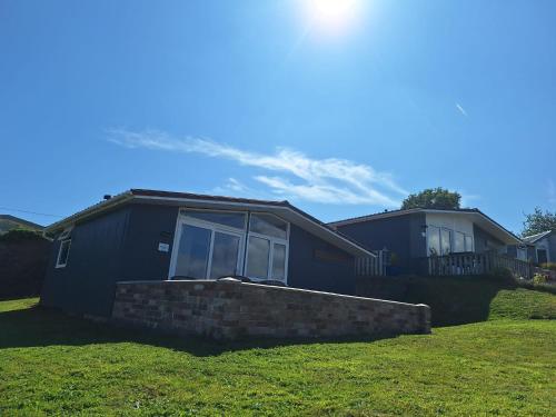 a blue house with a window in a yard at Eden Garden in Llangain