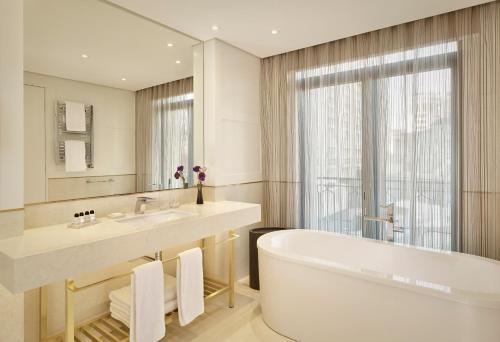 un bagno con vasca, lavandino e specchio di The Alexander, a Luxury Collection Hotel, Yerevan a Yerevan