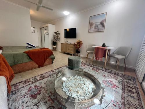 a living room with a bed and a table with chairs at Salty waves - D246 in Port Douglas