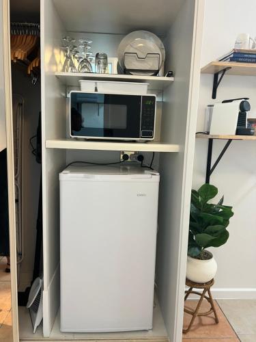 a microwave on top of a refrigerator in a pantry at Salty waves - D246 in Port Douglas