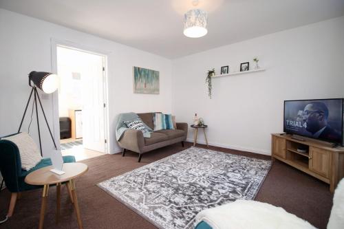 a living room with a television and a couch at Gwent View by Tŷ SA in Newport