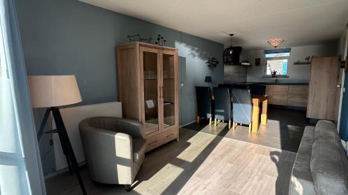 a living room with a couch and a dining room at Bungalow Ijsselmeer in Medemblik