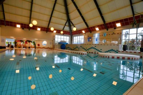a large indoor swimming pool with blue tiles at Bungalow Ijsselmeer in Medemblik