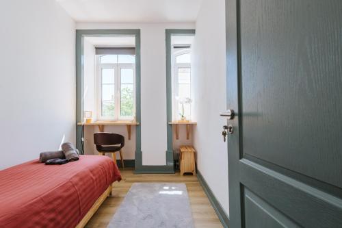a bedroom with a red bed and a door at Casa dos Loiros in Figueira da Foz