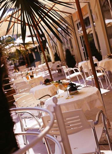 a restaurant with white tables and chairs and umbrellas at Hotel HamilTown in Cattolica