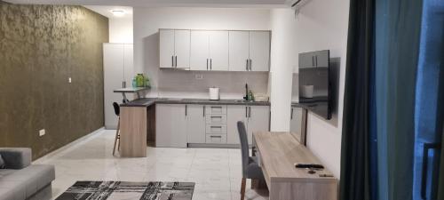 una cucina con mobili bianchi e un tavolo in una stanza di Avis 2 a Igalo