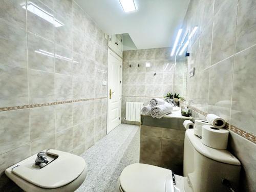 a bathroom with a toilet and a sink at Luxury Suite La Tribuna del Paseo in Granada