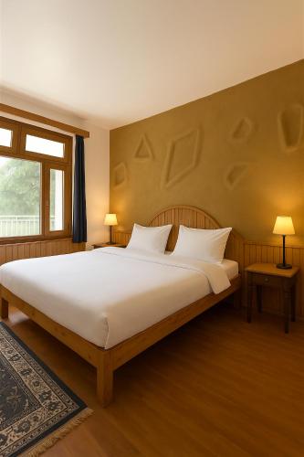 a bedroom with a large white bed and a window at Beholden Stay and Cafe - A Luxury Boutique Hotel in Manali in Manāli