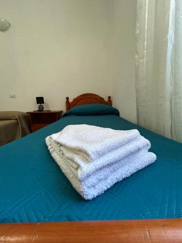 a stack of towels sitting on top of a bed at Adelina House in Olbia
