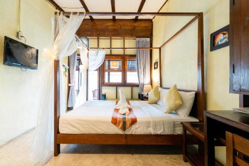 un dormitorio con una cama con dosel en Rompo Boutique Hotel, en Chiang Mai