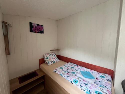 a small bedroom with a bed with a blue pillow at Apartmány Fialka in Třeboň