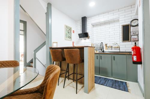una cocina con barra y algunas sillas. en Casa dos Loiros, en Figueira da Foz