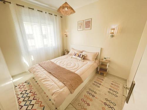 a bedroom with a bed with a window and a rug at Chic Design Stay With a Chocolate Welcome Gift in Agadir