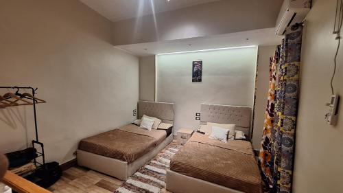 a small room with two beds and a mirror at Grand Duplex in Aswan