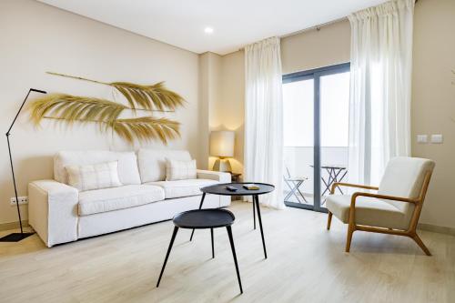 a living room with a white couch and a chair at Casa Ilda in Olhão