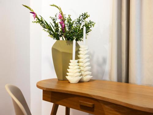 a vase with two candles on a table with flowers at homie stay Dominikus in Würzburg