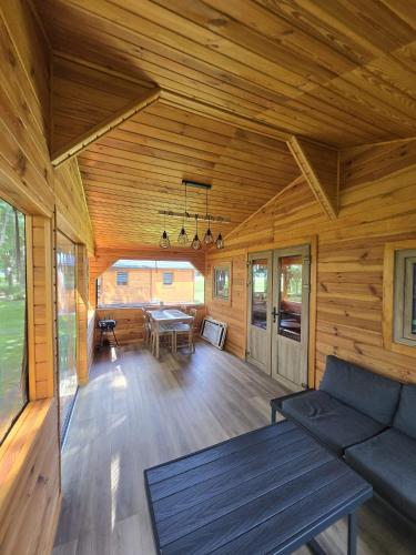 a living room with a couch and a table at Domki Pod Olchowym Dachem Lubie in Gudowo