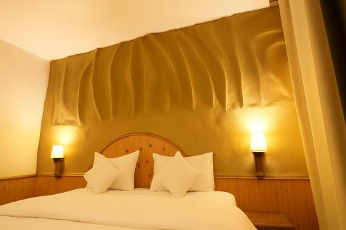 a bedroom with a bed with white sheets and pillows at Beholden Stay and Cafe - A Luxury Boutique Hotel in Manali in Manāli