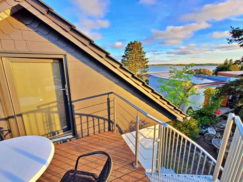 a balcony of a house with a table and chairs at Ferienwohnung OG Seglerblick am Achterwasser in Ziemitz