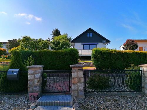 a gate in front of a house with bushes at Ferienhaus Seglerblick am Achterwasser in Ziemitz