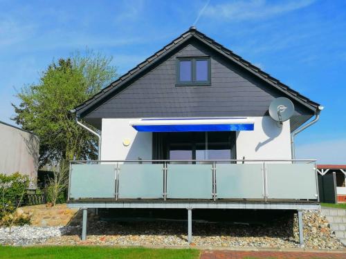 a house with a blue and white balcony at Ferienhaus Seglerblick am Achterwasser in Ziemitz