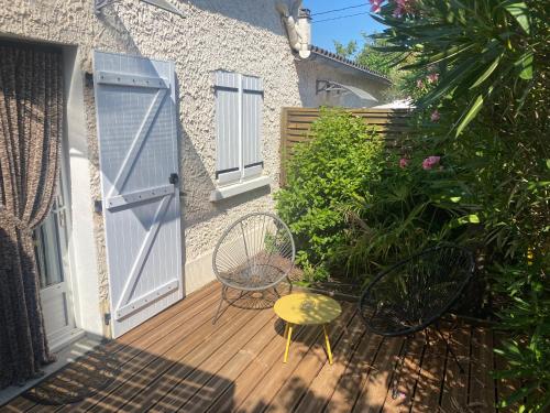 a wooden deck with a chair and a door at Gîtes Le Mas du Vieux Chêne in Salavas