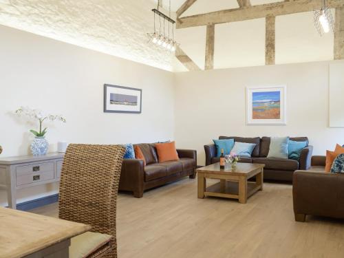 a living room with two couches and a table at The Garden Room At Eudon George in Shipton