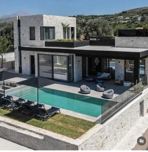 a house with a swimming pool and some chairs at Villa Andriano in Rethymno
