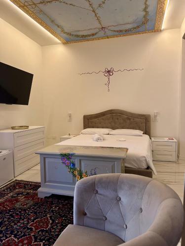 a bedroom with a bed and a tv and a chair at Limonaieincentro in San Benedetto del Tronto