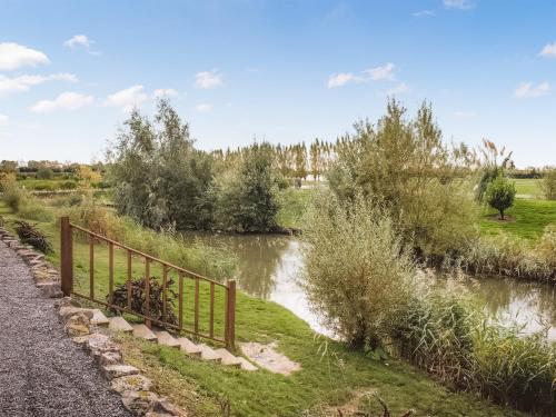 a river with a fence next to a road at 4 Lakeview Lodge in Boston