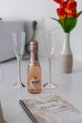 a bottle of champagne and two wine glasses on a table at Blue's Place - Stanza Accogliente - Wi-fi gratuito in Como