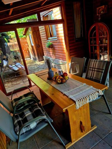 a wooden table with a bowl of fruit on a patio at RECI Beach Cottage in Reci