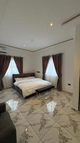 a large bedroom with a bed and a couch at Number 1 GREEKS AVENUE in Sunyani